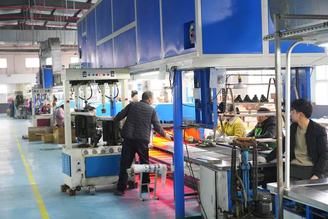 淮滨县星晖鞋业公司车间里生产热火朝天
