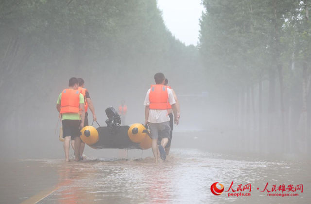 8月1日傍晚，救援人员正在带着冲锋舟奔向涿州市刁窝镇受灾村庄。 人民网 李兆民摄