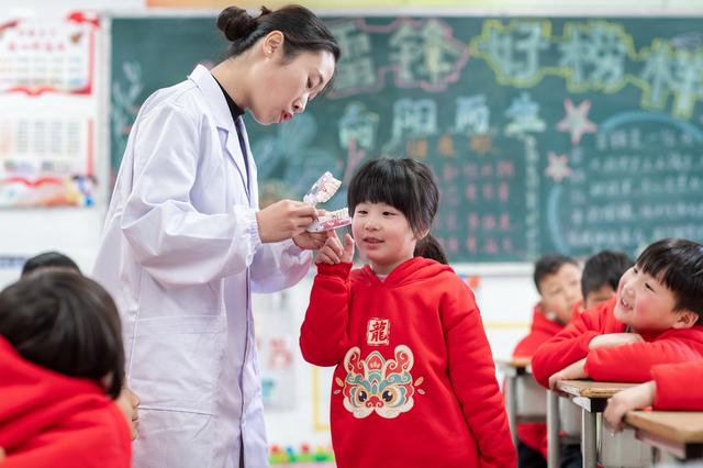 3月19日,在江苏省兴化市林湖中心校,医务人员为孩子们讲解口腔健康知识。新华社发(周社根摄)